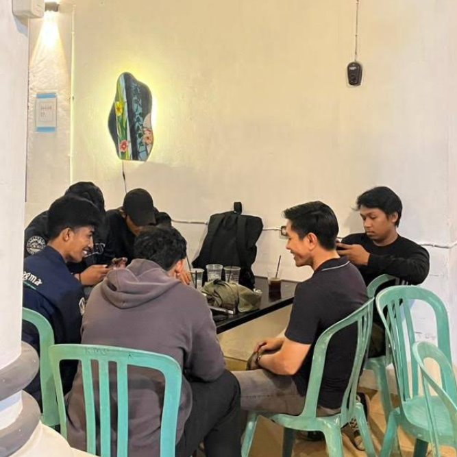 Teman-teman berbincang di area duduk dalam kafe.