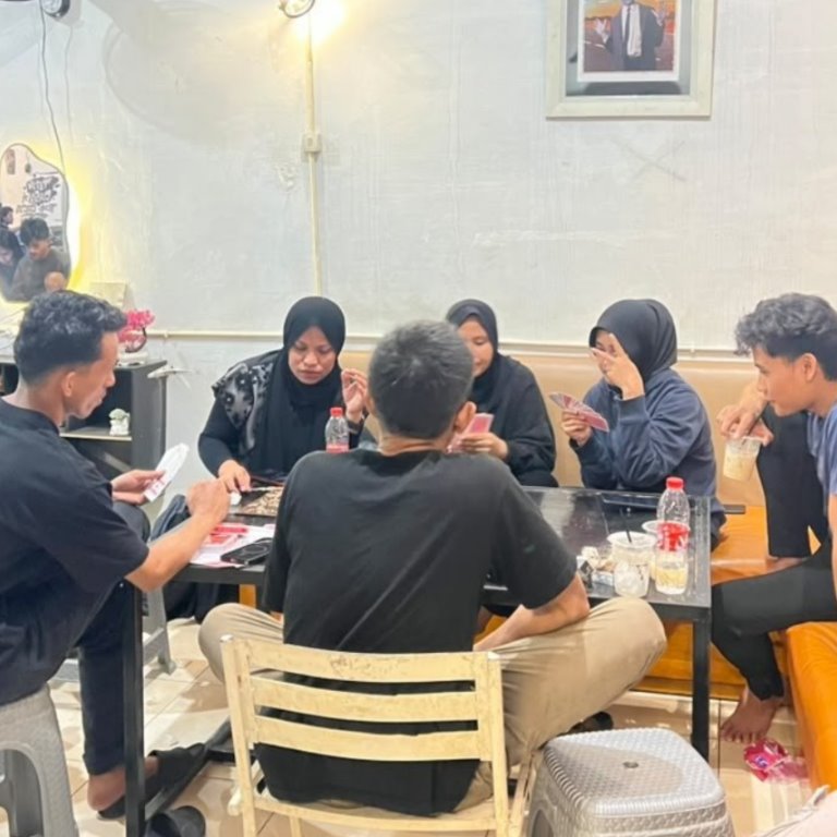 Pengunjung berbagi cerita di area bangku dalam kafe.