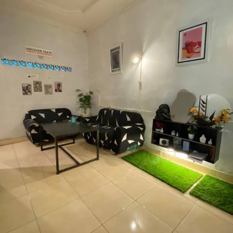 Area duduk dengan sofa bermotif dan dekorasi tanaman.