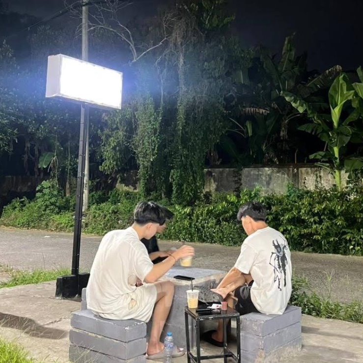 Pengunjung menikmati kopi di area luar pada malam hari.